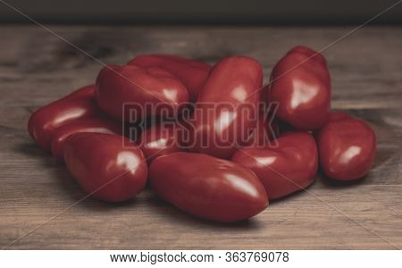 Shiny Red San Marzano Tomatoes (solanum Lycopersicum). Lucullus Type Italian Tomatoes On A Wood Tabl