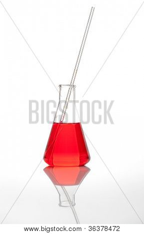 Laboratorio di Erlenmeyer matraccio conico - chiaro liquido mescolato con un reagente chimico colorato rosso, isolat