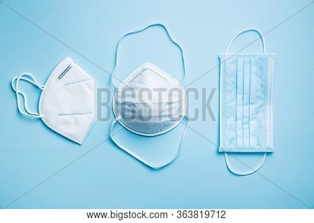 Three different protection face masks. Coronavirus prevention on blue background. Top view.