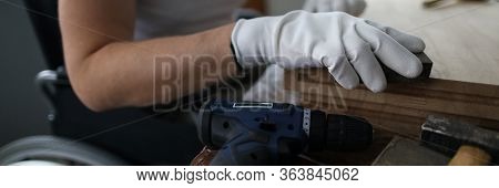 Man Sits In A Wheelchair And Works As Carpenter. Small Business For Disabled People Training Study C