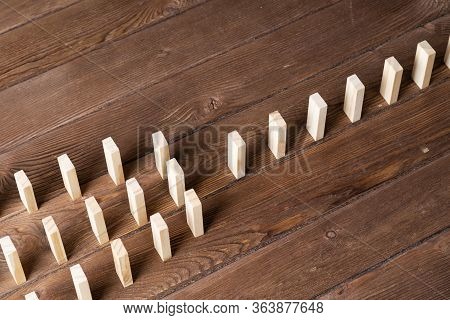 Rows Of Dominoes Standing On Wooden Table. Business Assistance And Management Concept With Wooden Bl