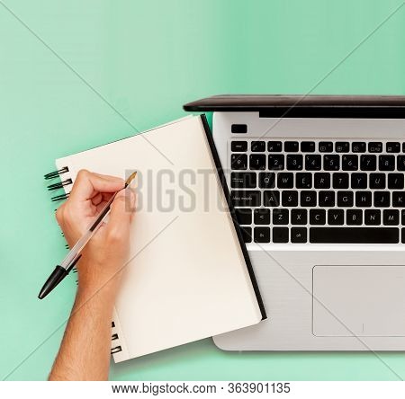 Professional Businessman Writing In Notepad. Workspace With Laptop And Agenda With Copy Space. Squar