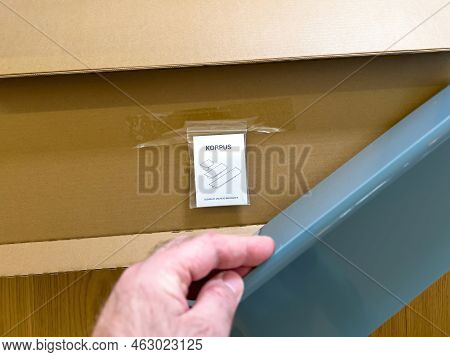 Paris, France - Apr 9, 2022: Pov Male Hand Unboxing Unpacking Danish Hay Korpus Shelf Furniture With