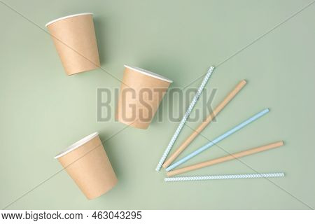 Eco - Friendly Tableware On Green Background. Top View. Plastic Free Set Of Brown Paper Utensil. Str