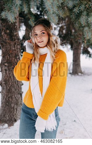 Teen Blonde In A Yellow Sweater Outside In Winter. A Teenage Girl On A Walk In Winter Clothes In A S