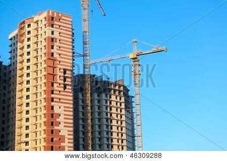 Opførelse af Highrise bygninger med kraner. Blå himmel baggrunden