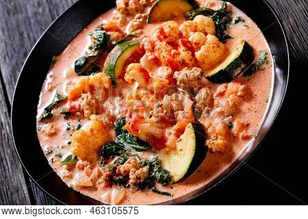 Close-up Of Creamy Tomato Soup With Ground Chicken, Cauliflower, Zucchini, Kale, Basil And Spices In