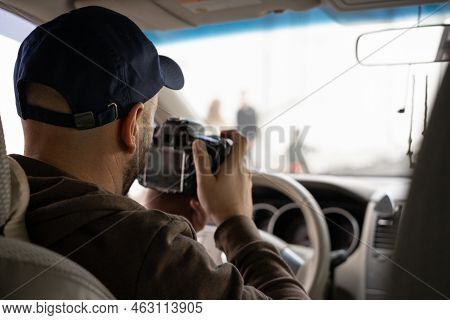 Private Detective Sitting Inside A Car Taking Pictures With A Reflex Camera