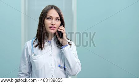 Young Woman General Practitioner Provides Telephone Consultation At Break. Dark-haired Doctor Advise