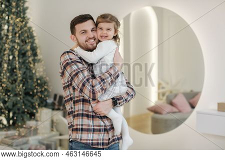 Adorable Daughter With Her Dear Father At Home In Gront Of Fit Tree. Chrisrmas Mood. Daughter Hug Fa