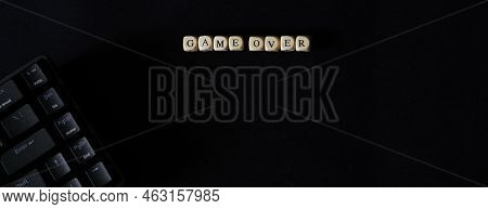Game Over Inscription Next To A Black Mechanical Keyboard On A Black Background. Gambling And The Pr