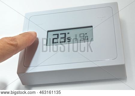 Lowering The Temperature Of A Home Thermostat Due To Energy Crisis. Close Up.