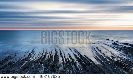 Stunning Sunset Landscape Image Of Welcome Mouth Beach In Devon England With Beautiful Rock Formatio