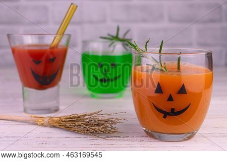 Drink Idea For Halloween Party. Drinks In Bottles With Monster Faces. Jack-o-lantern Face On Glass.