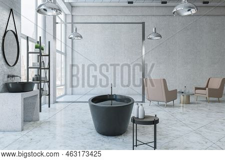 Side View On Black Stylish Bath With Water In Sunlit Spacious Loft Style Bathroom With Concrete Wall
