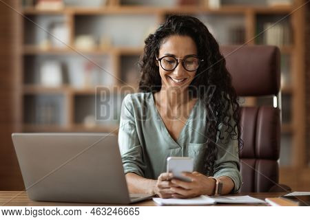 Cheerful Woman Entrepreneur Working Online, Using Smartphone And Laptop