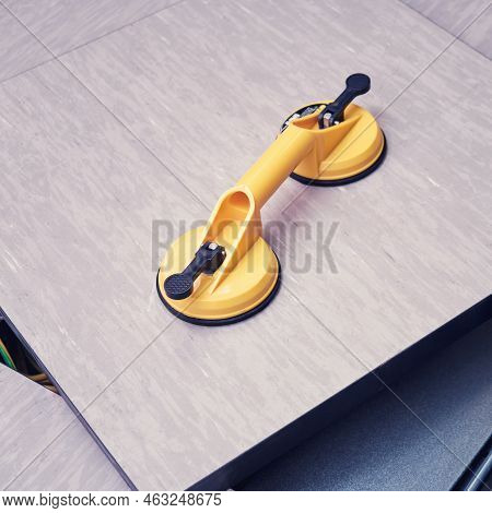 Yellow Handheld Device With Vacuum Suction Cups For Lifting Floor Panels