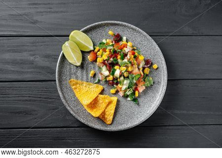 Texas Caviar On A Black Wooden Background. Top View. Texas Dish With Chips And Nachos On A Gray Plat