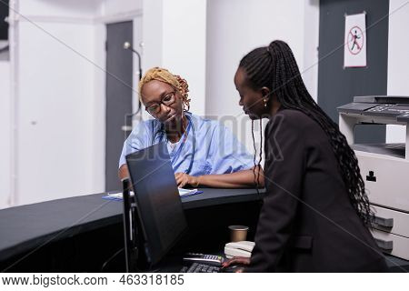 African American Medical Staff Analyzing Checkup Report With Patient Insurance Support On Papers. Nu