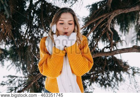 Teen Blonde In A Yellow Sweater Outside In Winter. A Teenage Girl On A Walk In Winter Clothes In A S