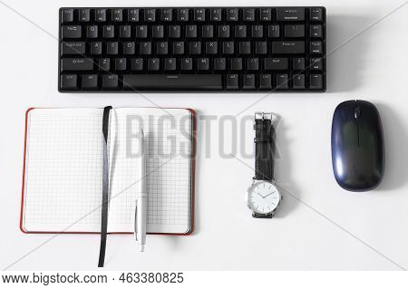 Portable Wireless Mechanical Computer Keyboard On A White Background Next To A Wristwatch, An Open N