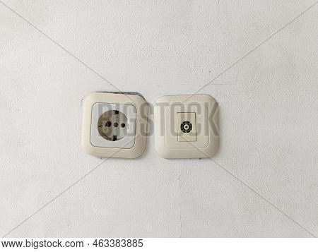 White Electric Socket On A White Wall. Cable Plug Hole For Electricity On The Wall. Power Outlet For
