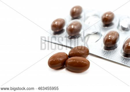 Medical Pills Capsules Of Brown Color On A White Background. Medicinal Preparations Of Plant Origin 