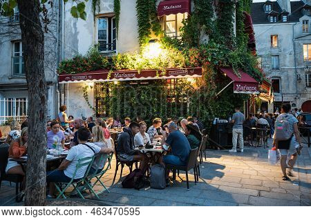 Paris, France - August 27 2022: People Walking And Dining In Cafe In The Evening In Famous The Marai