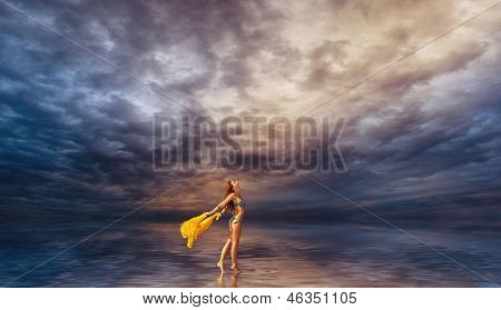 Kvinde med sarong gå på vandet i skumringen