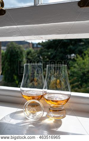 Two Glasses Of Single Malt Scotch Whisky Served On Old Window Sill In Scottisch House With View On O