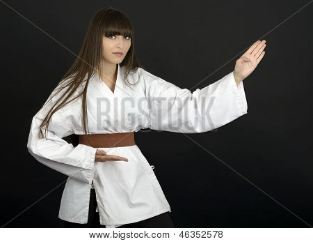 Karateka Asijská dívka na černém pozadí Studio Shot
