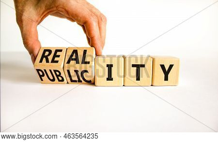 Reality Or Publicity Symbol. Businessman Turns Wooden Cubes And Changes The Word Publicity To Realit