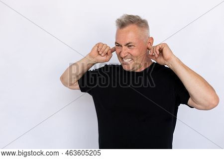 Senior Man Plugging Ears With Fingers. Male Model In Black T-shirt Covering Ears With Serious Angry 