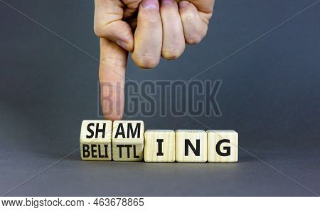 Shaming And Belittling Symbol. Concept Words Shaming And Belittling On Wooden Cubes. Businessman Han