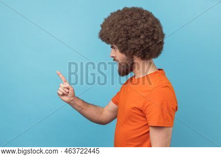 Side View Of Serious Man With Afro Hairstyle Wearing Orange T-shirt Standing With Admonishing Gestur