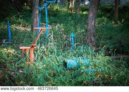 Old Outdoor Exercise Equipment So Worn Out And Covered In Trees In Outdoor Exercise Park. Old Abando