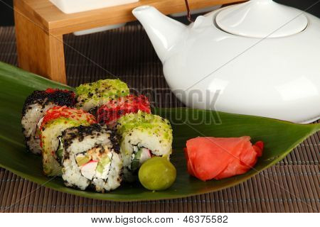 Velsmagende Maki sushi - Roll på grønne blade på grå baggrund