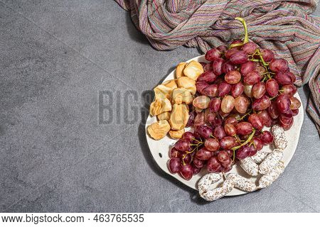 Snack Plate With Cheese, Grapes And Dried Sausages. Charcuterie Antipasto, Stone Concrete Background