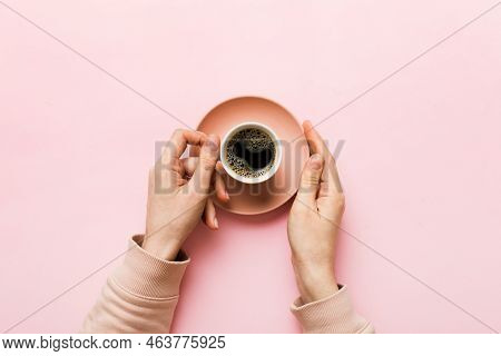 Minimalistic Style Woman Hand Holding A Cup Of Coffee On Colored Background. Flat Lay, Top View Capp