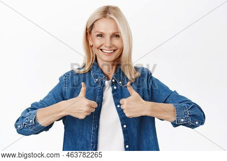 Energetic Senior Woman Shows Thumbs Up, Approve And Likes Smth Good, Praise You, Stands Over White B