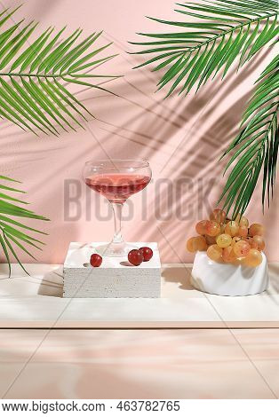 Modern Still Life With Alcoholic Martini  Cocktail And Grapes On Pastel Background With Long Hard Sh