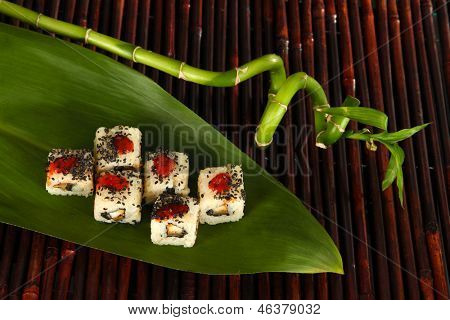 Velsmagende Maki sushi - Roll på grønne blade på bambus mat
