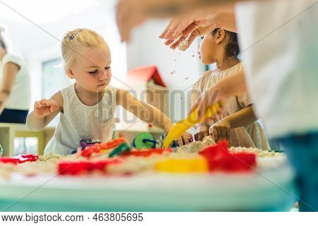 Adorable Blond Little Girl Focusing On Making Figures With Kinetic Sand In Kindergarten, Creative Ac