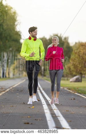 Sport Ideas And Concepts. City Running Couple Happily Jogging Outside As Runners Training Outdoors W