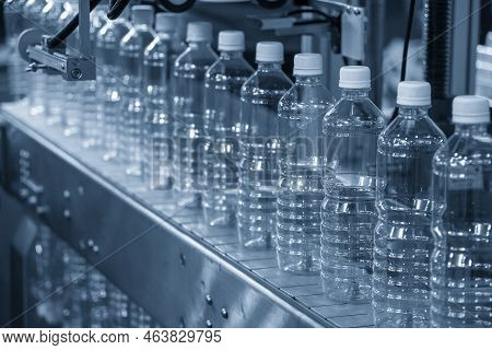 Close Up Scene Of The Empty Drinking Water Bottles  On The Conveyor Belt For Filling Process. The Hi