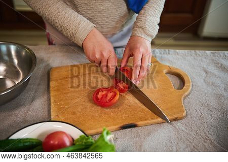 View From Above Of An Unrecognizable Woman, Housewife Using A Kitchen Knife, Chopping Tomatoes On A 