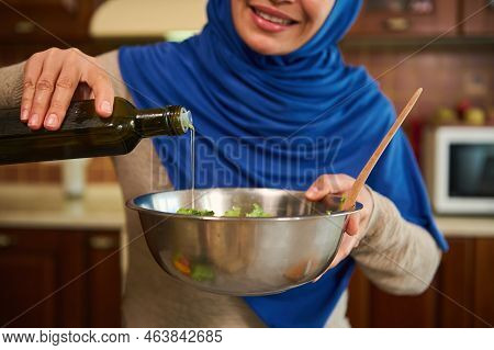 Close-up Of A Blurred Muslim Woman In Hijab, Smiling A Beautiful Toothy Smile, Pouring Olive Oil Int