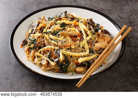 Korean Food Japchae With Meat, Egg, Vermicelli And Vegetables Closeup On The Plate On The Table. Hor