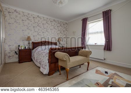Stradishall, Suffolk, England - June 1 2017 Furnished Bedroom With Feature Wall And Sleigh Bed.