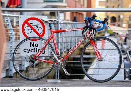 London, Uk - November 2, 2020: Red Bike Leaning Against A No Cycling Sign On Metal Railings At St Ka